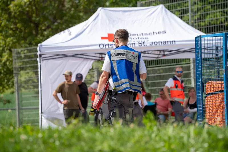 Gruppenführer vor dem Sanitätszelt des DRK St. Johann