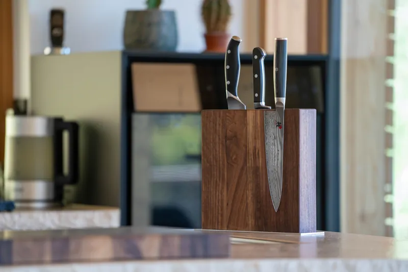 Messerblock aus dunklem Holz mit Damastmesser in der Küche