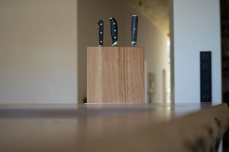 Messerblock aus hellem Holz mit drei Messern